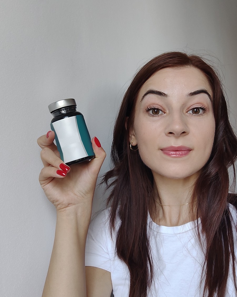 Claudia Sotîrca, farmacist diplomat, în tricou alb, cu un flacon în mână